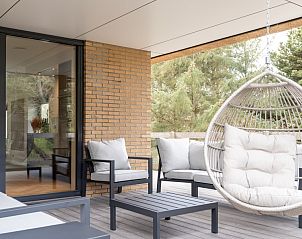 Veranda met hangstoel in vakantiehuis MIEKIE, Buren, Ameland, perfect voor ontspanning.