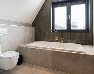 Badkamer met ligbad in vakantiehuis MIEKIE, Buren, Ameland, modern en comfortabel.