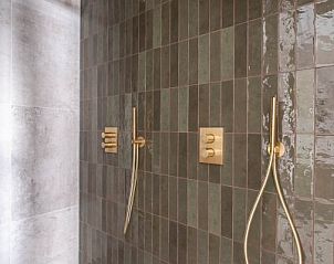 Luxe douche met gouden details in vakantiehuis MIEKIE, Buren, Ameland, stijlvol en modern.