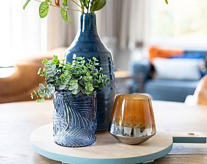 Decoratieve details op de tafel van Vakantiewoning De Las in Buren, Ameland, voegen charme toe aan het interieur.