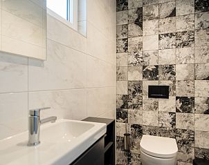 Lichte entree van Vakantiewoning De Las in Buren, Ameland, verwelkomt gasten met een warme sfeer op de Waddeneilanden.