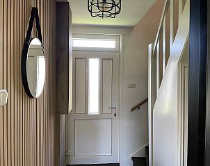 Eingangshalle des Ferienhauses WA003 in Buren, Ameland mit Spiegel und Treppe nach oben.