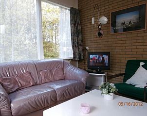Knusse zithoek in Bungalow Dolfijn, Buren, Ameland met televisie en natuurlijke lichtinval.