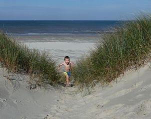 Kind speelt in de duinen bij Bungalow Dolfijn, Buren, Ameland met uitzicht op de zee.