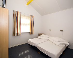 Knusse slaapkamer in Bungalow 18, Buren, Ameland met twee bedden en natuurlijk licht.