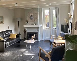 Comfortabele woonkamer met open haard in Beppe van Ameland vakantiehuis, Hollum, Ameland.