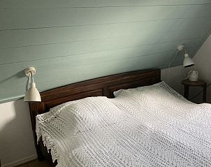 Romantische slaapkamer met houten bed in Beppe van Ameland, Hollum, Ameland.