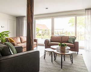 Gezellige woonkamer in Langsdeel appartement, Hollum, Ameland, met comfortabele banken en veel lichtinval.