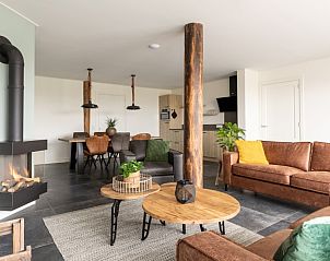 Open haard en zithoek in Langsdeel appartement, Hollum, Ameland, met houten details en moderne inrichting.