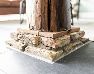 Authentieke houten steunpilaar in Langsdeel appartement, Hollum, Ameland, met rustieke details.