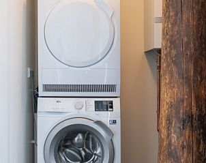 Wasruimte in Langsdeel appartement, Hollum, Ameland, met wasmachine en droger.