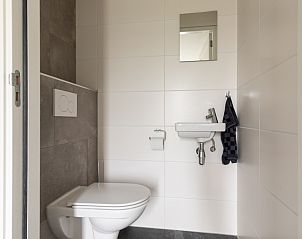 Moderne badkamer in Langsdeel appartement, Hollum, Ameland, met hangend toilet en wastafel.