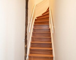 Houten trap in Langsdeel appartement, Hollum, Ameland, leidt naar de bovenverdieping.