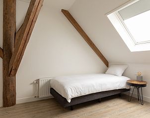 Slaapkamer met houten balken in Langsdeel appartement, Hollum, Ameland, met eenpersoonsbed.