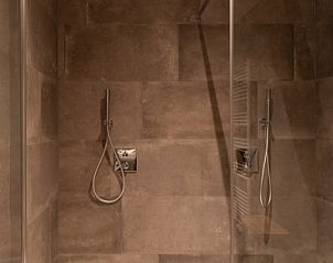 Dubbele douche in Langsdeel appartement, Hollum, Ameland, met moderne afwerking en regendouches.