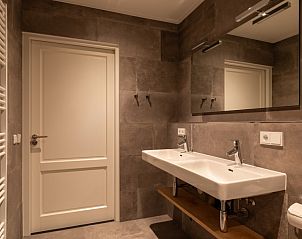 Badkamer met dubbele wastafel in Langsdeel appartement, Hollum, Ameland, met moderne inrichting.