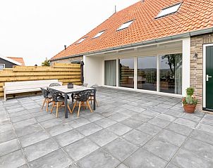 Ruim terras in Langsdeel appartement, Hollum, Ameland, met tuinmeubilair en uitzicht op de omgeving.