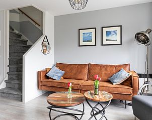 Gezellige woonkamer Amelander Kaap 126, Hollum, Ameland met comfortabele bank.