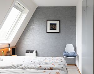 Slaapkamer met groot raam en decor in Amelander Kaap 126, Hollum, Ameland.