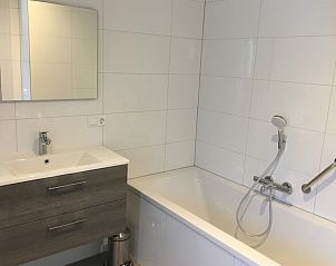 Moderne badkamer van Bornrif Luxe 6 bungalow in Hollum, Ameland, Waddeneilanden met ligbad en stijlvolle wastafel.