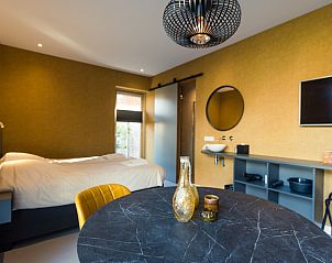 Gezellige eethoek in Breeze 1 appartement, Hollum, Ameland, met ronde tafel en stijlvolle decoratie.