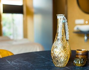 Stijlvolle decoratieve details in Breeze 1 appartement, Hollum, Ameland, met een elegante vaas op tafel.