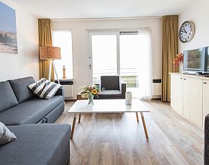 Lichte woonkamer met moderne inrichting in Zilverschoon appartement, Hollum, Ameland, met toegang tot terras.
