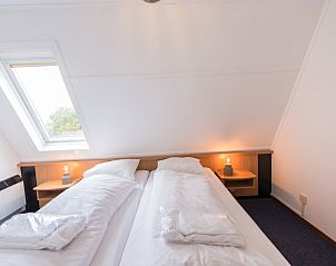 Knusse slaapkamer met tweepersoonsbed in Zilverschoon accommodatie, Hollum, Ameland, met dakraam voor natuurlijk licht.