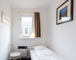 Lichte eenpersoonskamer in Zilverschoon appartement, Hollum, Ameland, met uitzicht op de omgeving.