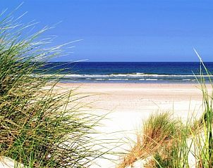 Prachtig strandlandschap nabij Zilverschoon, Hollum, Ameland, met uitgestrekt zand en helderblauwe zee.