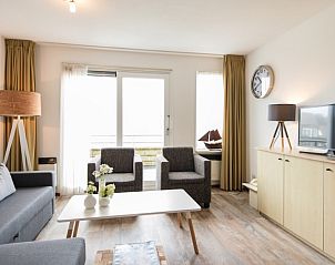 Stijlvolle zithoek in Wad appartement, Hollum, Ameland met moderne inrichting en veel natuurlijk licht.