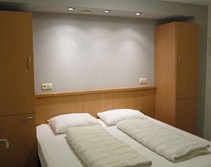 Comfortabele slaapkamer in Appartment Amelander Kaap, Hollum, Ameland met tweepersoonsbed en sfeervolle verlichting.