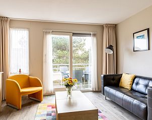 Ruime woonkamer in Bornrif appartement, Hollum, Ameland met toegang tot balkon.