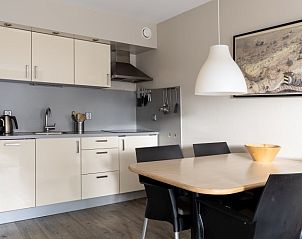Moderne keuken in Bornrif vakantieappartement, Hollum, Ameland met eettafel en apparatuur.