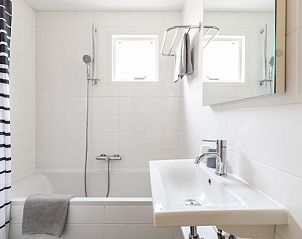 Stijlvolle badkamer in Bornrif, Hollum, Ameland met bad en moderne voorzieningen.