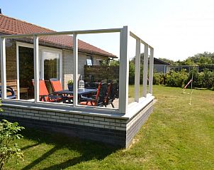 berdachte Veranda des Kleefkruid-Bungalows, Hollum, Ameland mit Sitzgelegenheiten.