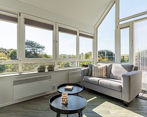 Zonnige woonkamer in Zand appartement, Nes, Ameland, met toegang tot het terras.