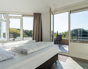 Uitzicht vanuit de slaapkamer van Zand appartement, Nes, Ameland, met toegang tot balkon.