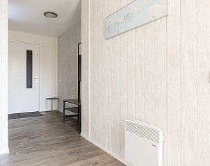 Entree van Zand appartement, Nes, Ameland, met houten vloer en lichte muren.