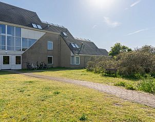 Buitenkant van Zand appartement, Nes, Ameland, met toegang tot groene tuin.