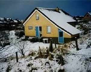 Sneeuw bedekt In Het Dal vakantiehuis in Buren, Ameland, met winterse charme.