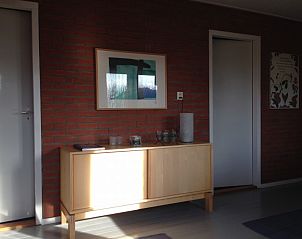 Stijlvolle binnenruimte van In Het Dal vakantiehuis in Buren, Ameland, met kunst aan de muur.