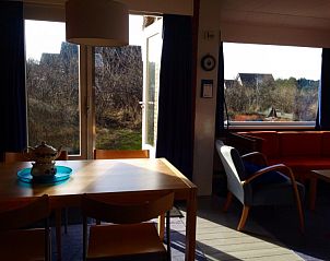 Eethoek bij In Het Dal vakantiehuis in Buren, Ameland, met zicht op de tuin.