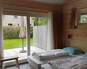 Slaapkamer met openslaande deuren naar terras in Ascona, Nes, Ameland.