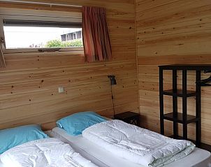 Ruime slaapkamer met houten interieur in Ascona vakantiehuis, Nes.