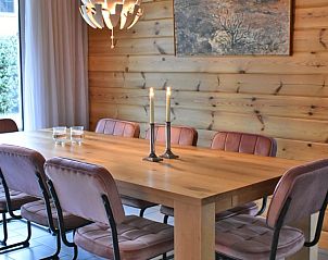 Eetkamer met houten tafel in Ascona bungalow, Nes, Ameland.