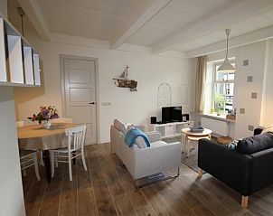 Gezellige woonkamer in Westhoek, Schiermonnikoog, met comfortabele banken en lichte inrichting.