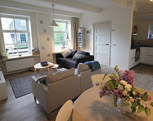 Westhoek vakantiehuis, Schiermonnikoog, open leefruimte met eetgedeelte en uitzicht op de tuin.