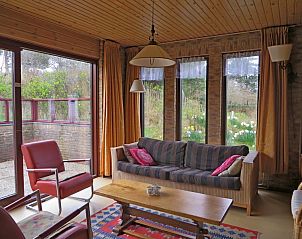 Gezellige woonkamer in Duinrust, Schiermonnikoog, met uitzicht op de natuurlijke omgeving.