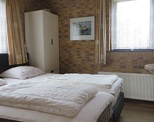 Knusse slaapkamer in vakantiehuis Duinrust, Schiermonnikoog, met veel natuurlijk licht.